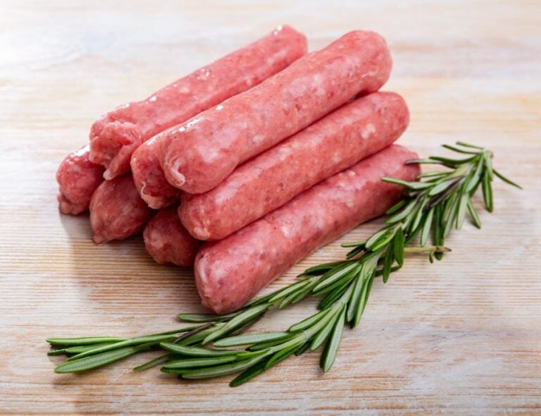 Raw Pork Sausage Next to Herbs