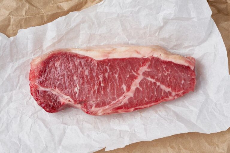 Large, Raw Steak on Paper Packaging
