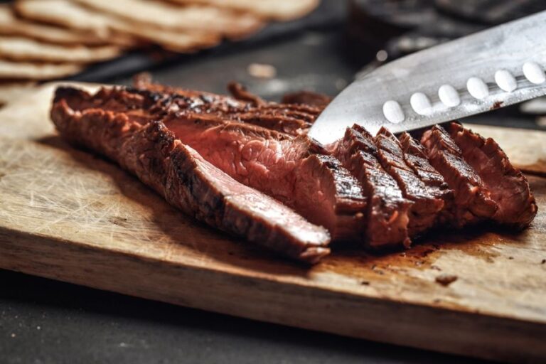 Cutting Slices of Flank Steak on Wooden Cutting Board