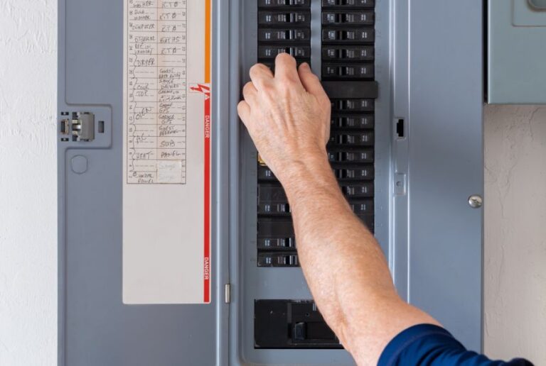 Man Resetting Tripped Breaker in an Electrical Panel or Circuit Breaker Box