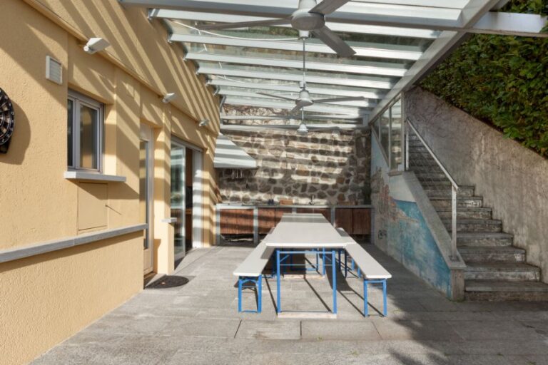 Outdoor Patio Covered With a Pergola With Several Fans