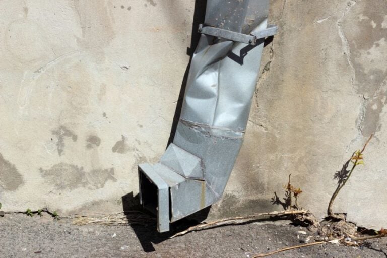 Crushed Downspout on the Side of a Building