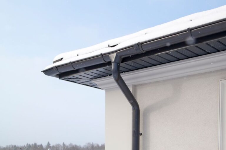 Black Gutters With a Downspout on a House