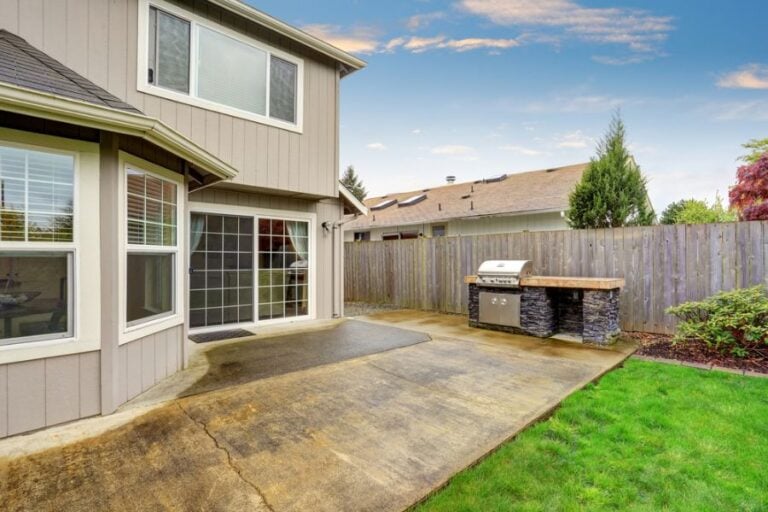 Concrete Patio Behind House With Cracks in Need of Leveling