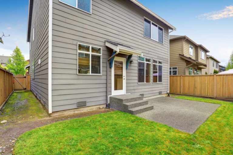 Two Story House With a Small Older Concrete Patio