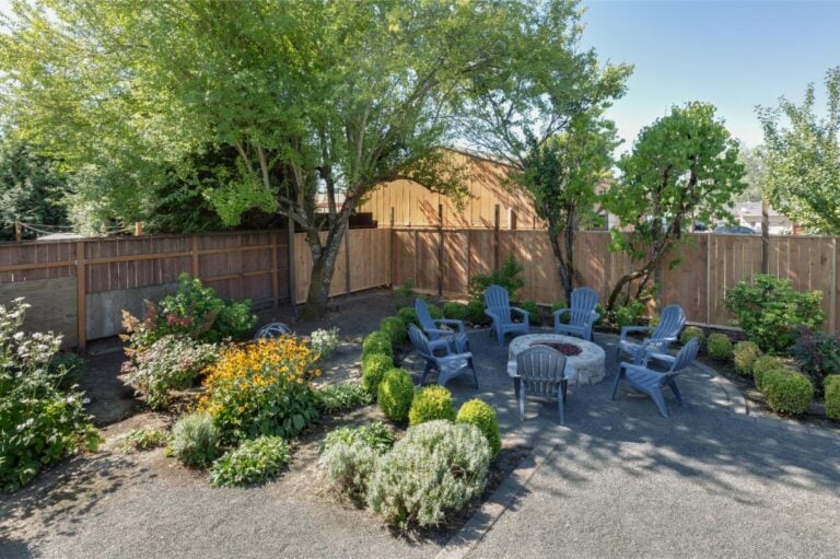 Fire Pit in Backyard Surrounded by Adirondack Chairs